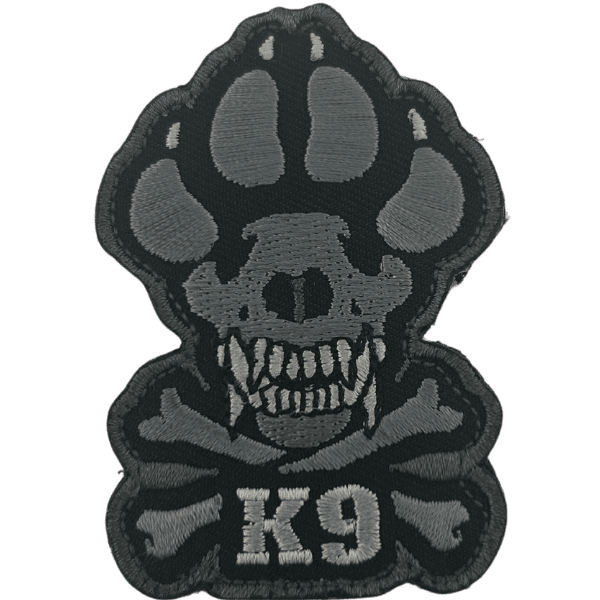 A woven velcro patch with a crossbones and the paw of a working dog with "K9" embroidered on it.