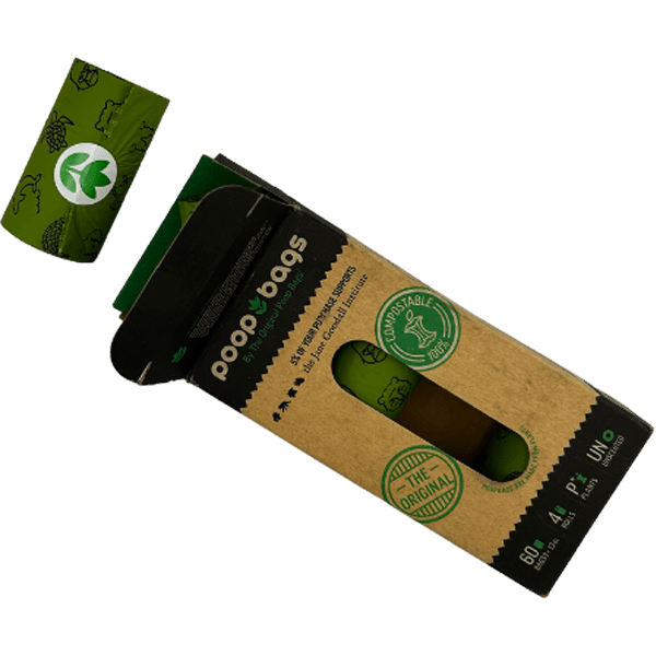 One green poop bag roll outside of open black and brown packaging.